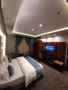a hotel room with a bed and a television at شقق نيروز ان للوحدات المخدومة in Jeddah