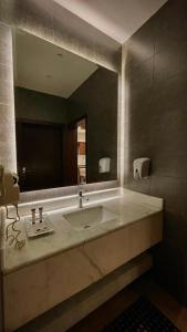 a bathroom with a sink and a large mirror at شقق نيروز ان للوحدات المخدومة in Jeddah