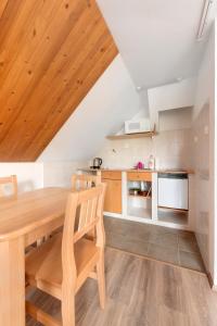 een keuken met een houten tafel en stoelen in een kamer bij Penzion Samoty in Železná Ruda