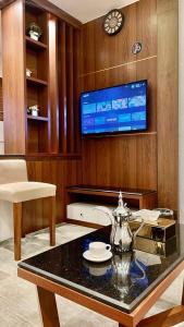 a living room with a table and a tv at شقق نيروز ان للوحدات المخدومة in Jeddah