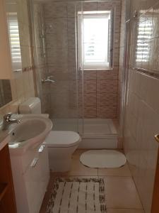 een badkamer met een douche, een toilet en een wastafel bij Apartments Antica in Rab +94 foto's