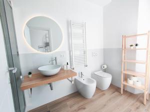 łazienka z 2 umywalkami, lustrem i toaletą w obiekcie S&M Apartments "Casa Gemma" - Cimiano M2 w Mediolanie +10 zdjęć