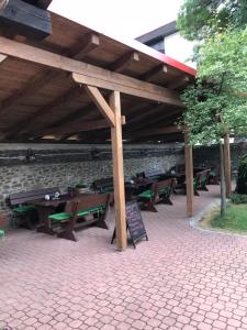 a group of picnic tables under a wooden roof at Penzion U Jelena in Železná Ruda