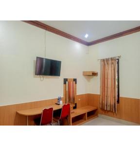 um quarto com uma mesa e uma televisão de ecrã plano em Homestay Akik Hijau Near Panakkukang em Pampang