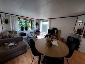 a living room with a table and a couch at Heerlijk chalet in prachtige natuur. in Doornspijk