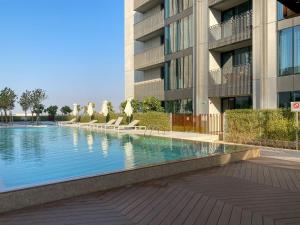 a swimming pool in front of a building at Modern Urban 3 bedroom apartment Dubai Creek Harbour in Dubai
