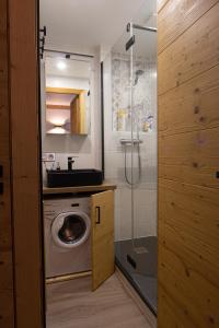 a bathroom with a washing machine and a sink at Courchevel 1550 - SUPERBE appartement SKIS AUX PIEDS ! in Courchevel