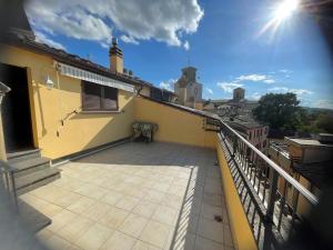 einen Balkon eines gelben Gebäudes mit der Sonne am Himmel in der Unterkunft Casa VACANZE ONELIA in Gualdo Tadino