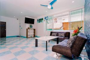 a living room with a couch and a table at PATONG BLUE HOTEL in Patong Beach