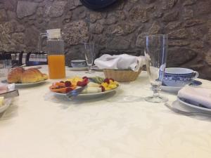 une table avec des assiettes de nourriture et des verres dans l'établissement Casa do Nato -Turismo Rural, à Viana do Castelo