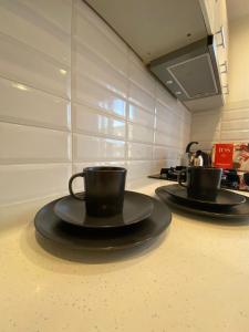 two coffee cups on a counter in a kitchen at Nameja Best view apartamenti in Jēkabpils