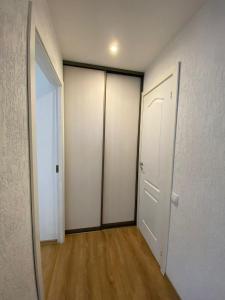 an empty hallway with four closets and a door at Nameja Best view apartamenti in Jēkabpils