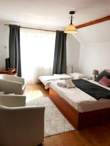 1 dormitorio con 2 camas y 1 silla en D&D Busteni en Buşteni