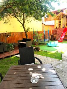 a wooden table and chairs in a backyard with a playground at D&D Busteni in Buşteni