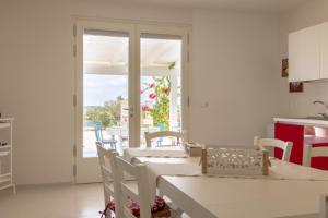 a white kitchen with a table and chairs and a window at Villa Peter in Ostuni