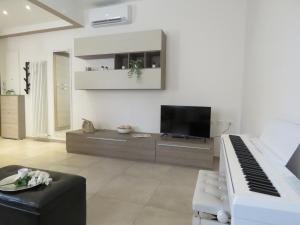 a living room with a piano and a television at Pasubio Apartment in Bologna