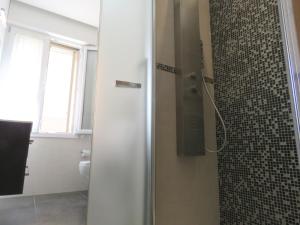 a bathroom with a shower with a glass door at Pasubio Apartment in Bologna