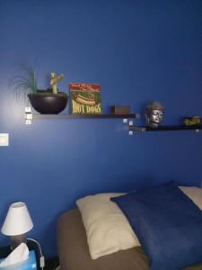 een blauwe slaapkamer met een bed en een blauwe muur bij CHRISMARIE in Bois-Guillaume