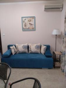 niebieska kanapa z poduszkami w salonie w obiekcie Villa Gracia w Rawdzie