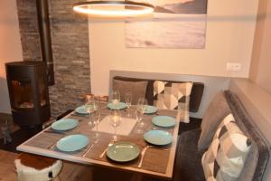 einen Esstisch mit Tellern und Weingläsern in der Unterkunft L'Aubépine 2 in Montalbert
