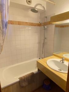 a bathroom with a bath tub and a sink at le signal 105 apartment in residence 50 meters from slopes 4-6 people in Montalbert