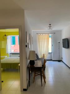 Zimmer mit einem Bett und einem Tisch mit einer Lampe in der Unterkunft Appartamento Veneto by Vacanze in Chiavari in Chiavari