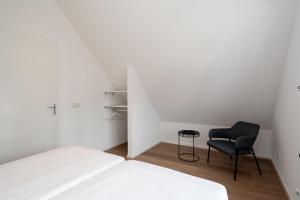 1 dormitorio con 1 cama y 1 silla negra en Holiday, en Hensbroek