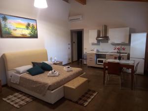 uma sala de estar com uma cama e uma cozinha em Mazzi House Garden em Dossobuono
