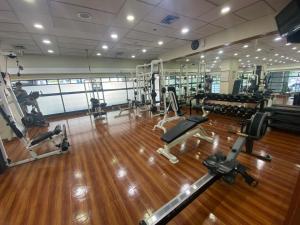 a gym with several treadmills and machines in it at Grand Tropic Suites Hotel in Jakarta