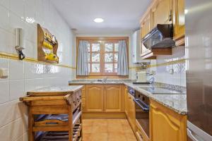 uma cozinha com armários de madeira e uma bancada em Luderna - Apartamento D1 del Seig de Canillo - ANDORRA em Canillo