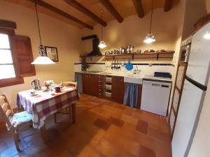 a kitchen with a table and a kitchen with a stove at Mas del Salin in Cornudella