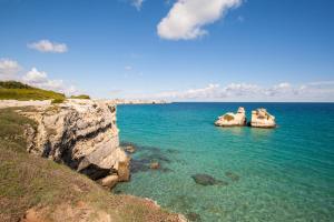 zwei große Felsen im Wasser nahe der Küste in der Unterkunft Villetta Poesia 50 m dal mare con giardino e parcheggio in Torre dell'Orso