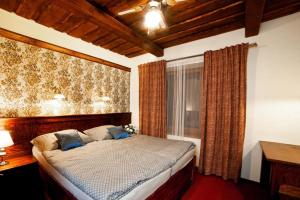 Un dormitorio con una cama con almohadas azules y una ventana en Hotel Galerie, en Roudnice nad Labem