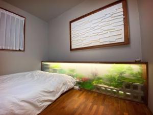 - une chambre avec un lit et un aquarium sur le mur dans l'établissement Viva La Vida - Seochon Private Apartment, à Séoul
