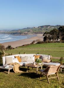 1 sofá, 2 sillas, 1 mesa y 1 playa en Espectacular Villa con acceso privado a la playa de Oyambre, en San Vicente de la Barquera