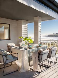 uma sala de jantar com uma mesa branca e cadeiras em Espectacular Villa con acceso privado a la playa de Oyambre em San Vicente de la Barquera