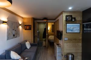 een woonkamer met een blauwe bank in een tiny house bij Courchevel 1550 - SUPERBE appartement SKIS AUX PIEDS ! in Courchevel