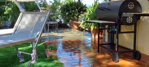 a bbq grill in a backyard with a patio at Casa Vacanze Principesca in Pescantina