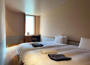 a hotel room with two beds with towels on them at kamakura seizan in Kamakura
