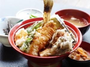 un tazón rojo de comida con una cuchara dentro en Shinyu Onsen Kurikomaso en Kurihara