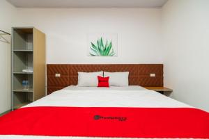 um quarto com um cobertor vermelho numa cama em RedDoorz @ Aldos Villa Silangit em Siborongborong