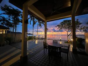 a patio with a table and chairs with a view of the water at Bonheur at Karambunai in Kota Kinabalu