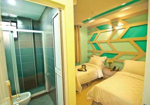 a bedroom with a bed and a glass shower at Sunshine Inn in Melaka