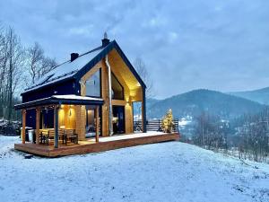 una cabaña de madera en la nieve en las montañas en CzillChata, en Maków Podhalański