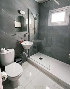 a bathroom with a toilet and a shower and a sink at Fotoxenia Luxury Apts in Paralimni
