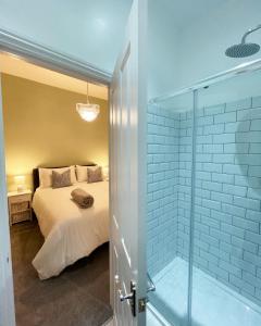 a bedroom with a bed and a glass shower at The Berwick Inn in Polegate