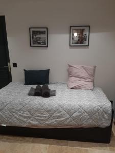 a bed with a pair of shoes sitting on it at la studette du théâtre in Boulogne-Billancourt