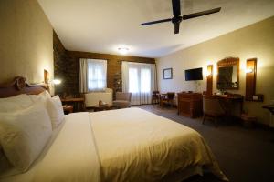 a hotel room with a large bed and a desk at The Mill Hotel in Kakopetria