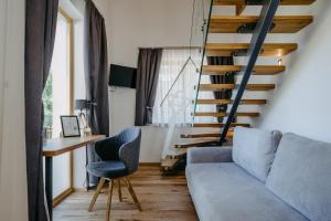 a living room with a couch and a desk and stairs at Weinberg Chalet 2 in Eisenberg an der Pinka