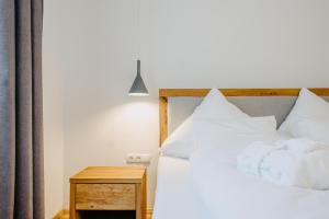 a bedroom with a bed with white pillows and a table at Weinberg Chalet 2 in Eisenberg an der Pinka +10 photos